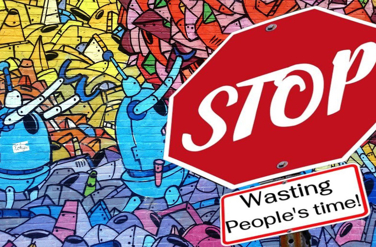 stop sign with the words "wasting people's time" under it.